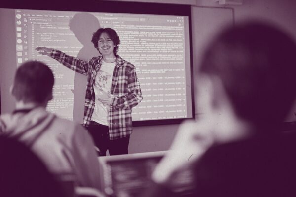 En lärare undervisar om programmering för elever i ett klassrum.